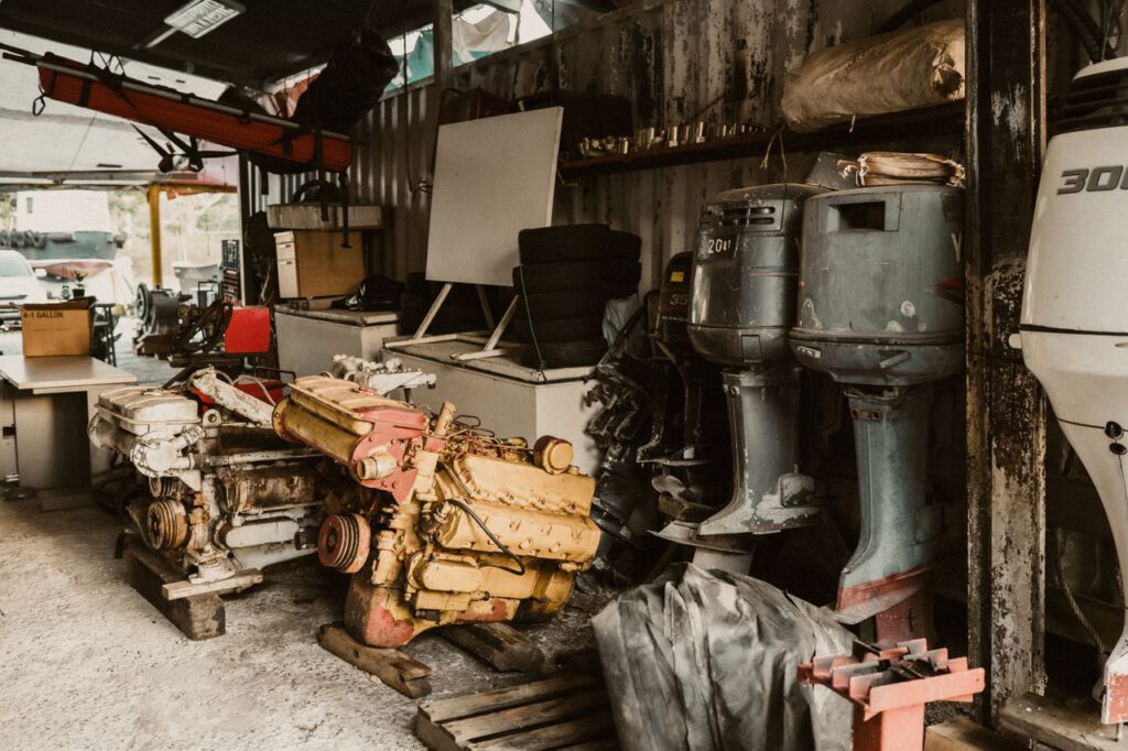 pexels photo 16135856 16135856 Interior of a workshop featuring engines, machinery, and outboard motors in a rustic setting.